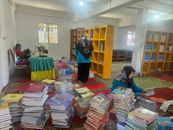 Guru dan Siswi MTsN 2 Sungai Penuh Tata Buku Perpustakaan Baru