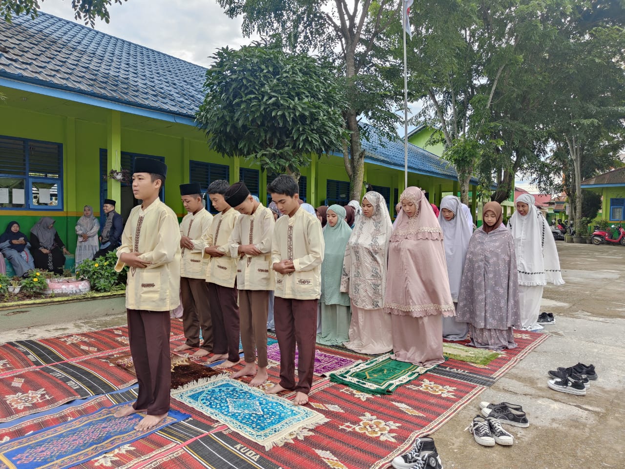 Praktik ibadah di lapangan madrasah yang didampingi langsung oleh guru